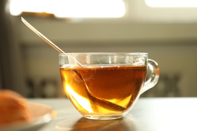 Photo of Tasty tea with sugar and spoon on table, closeup