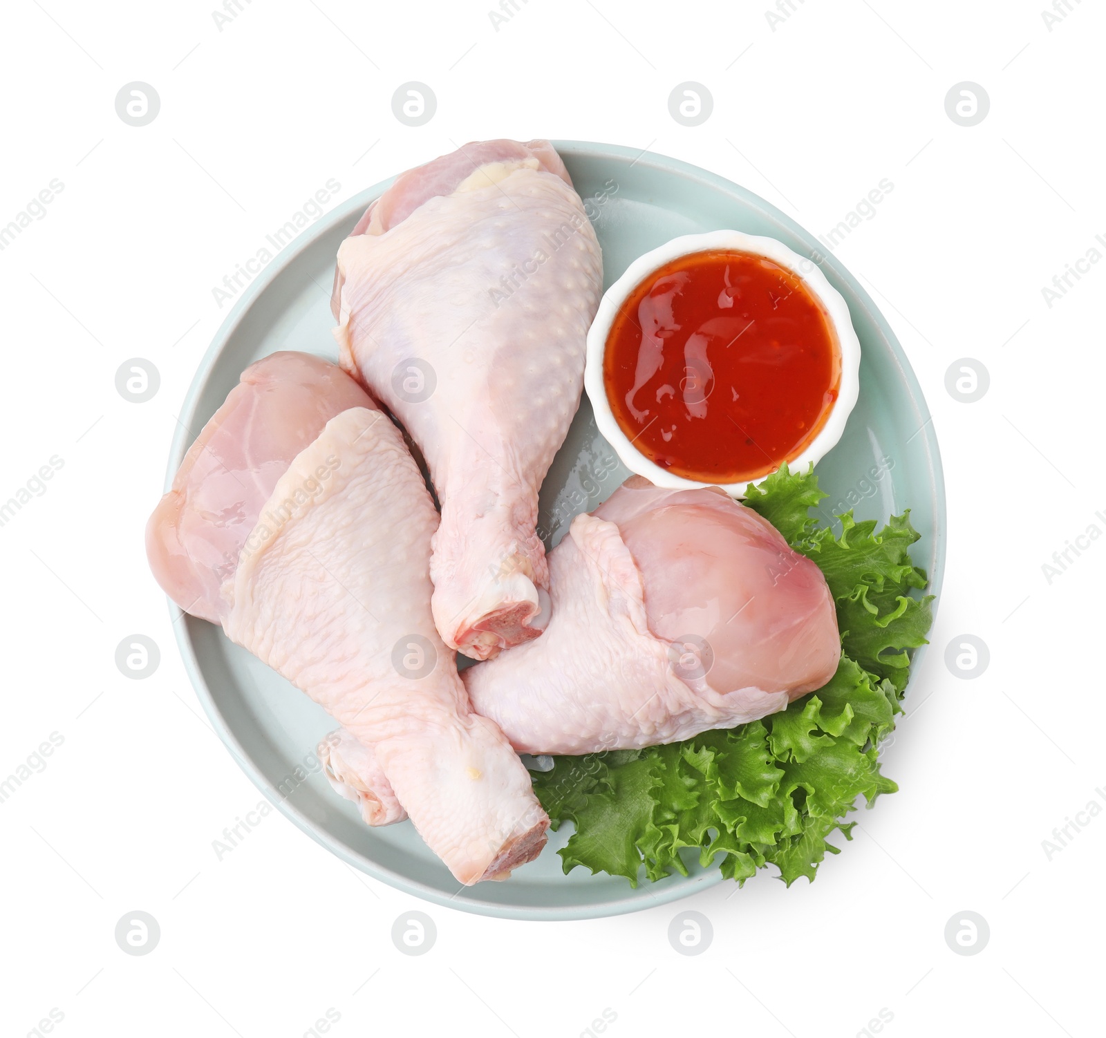 Photo of Fresh marinade, raw chicken drumsticks and lettuce isolated on white, top view