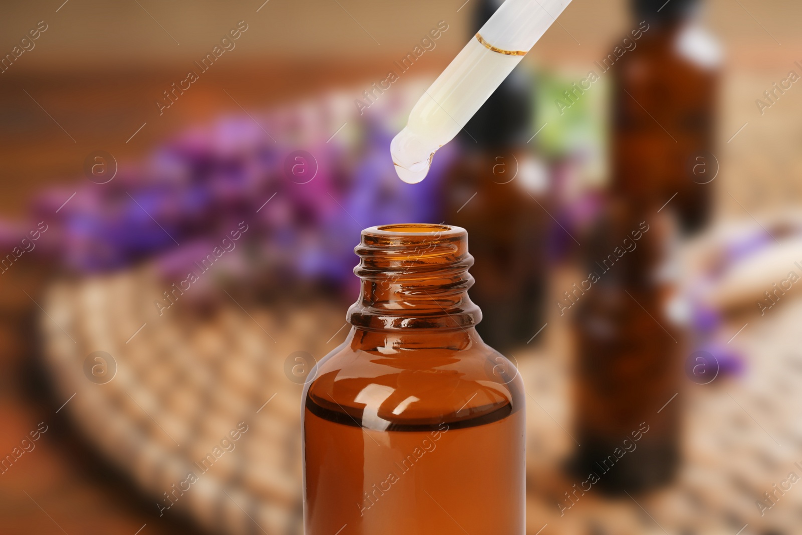 Image of Little bottle with essential oil and dropper against blurred background 