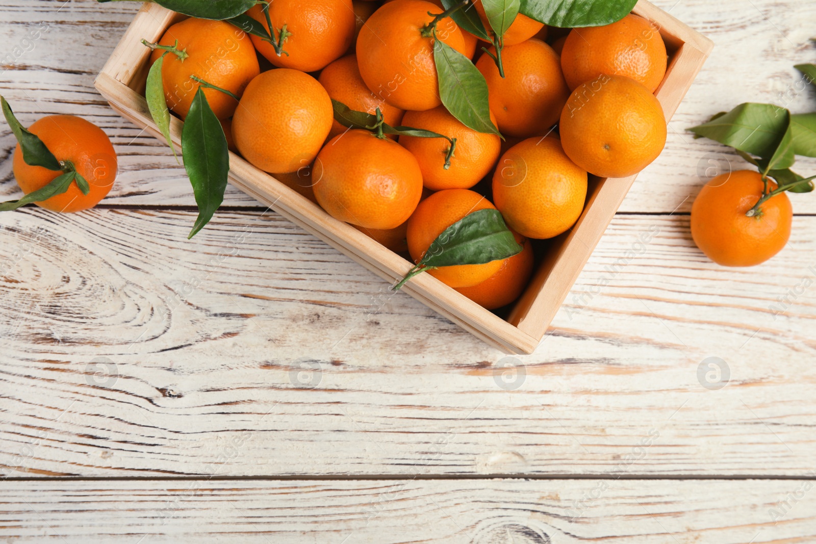 Photo of Crate with fresh ripe tangerines and space for text on wooden background, top view