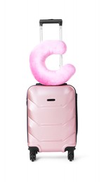 Photo of Pink travel pillow on suitcase against white background