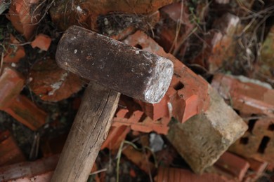 Photo of Sledgehammer on pile of broken bricks outdoors, above view