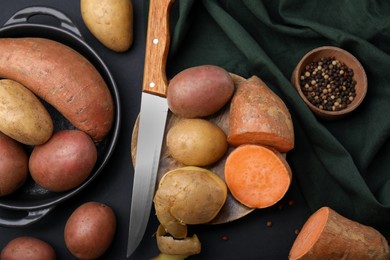 Photo of Different types of fresh potatoes on black table, flat lay