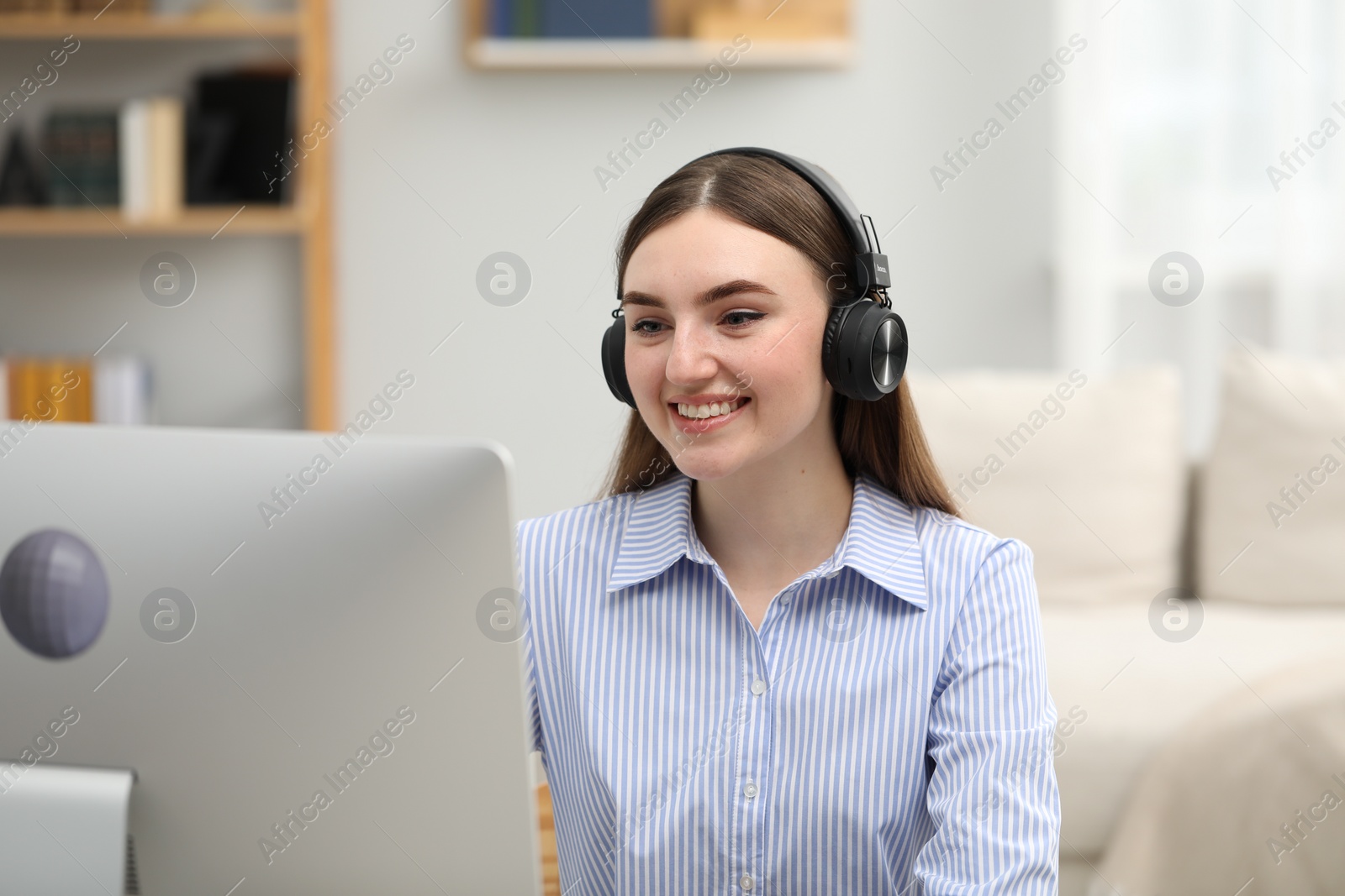 Photo of E-learning. Young woman studying with computer during online lesson indoors.