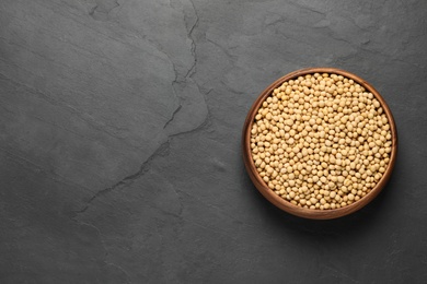 Photo of Soy in bowl on black table, top view. Space for text