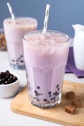 Bubble milk tea with tapioca balls on table against blue background