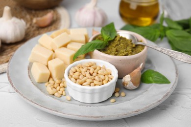 Photo of Tasty pesto sauce and ingredients on white table, closeup