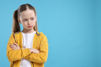 Photo of Portrait of sad girl on light blue background, space for text