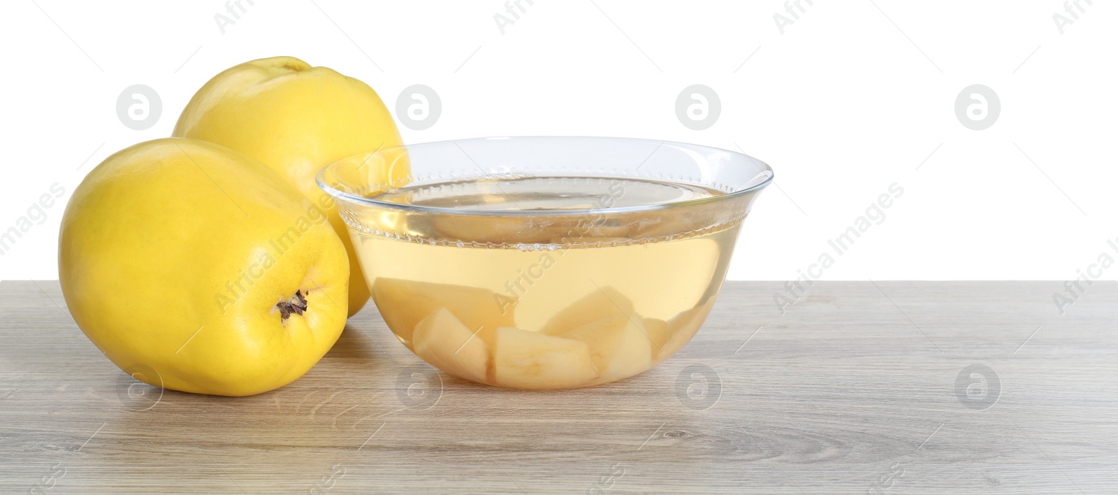 Photo of Delicious quince drink and fresh fruits on wooden table against white background