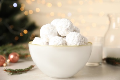 Photo of Christmas snowball cookies in bowl on light table