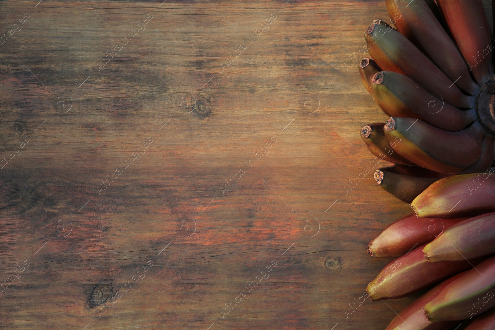 Photo of Tasty purple bananas on wooden table, top view. Space for text