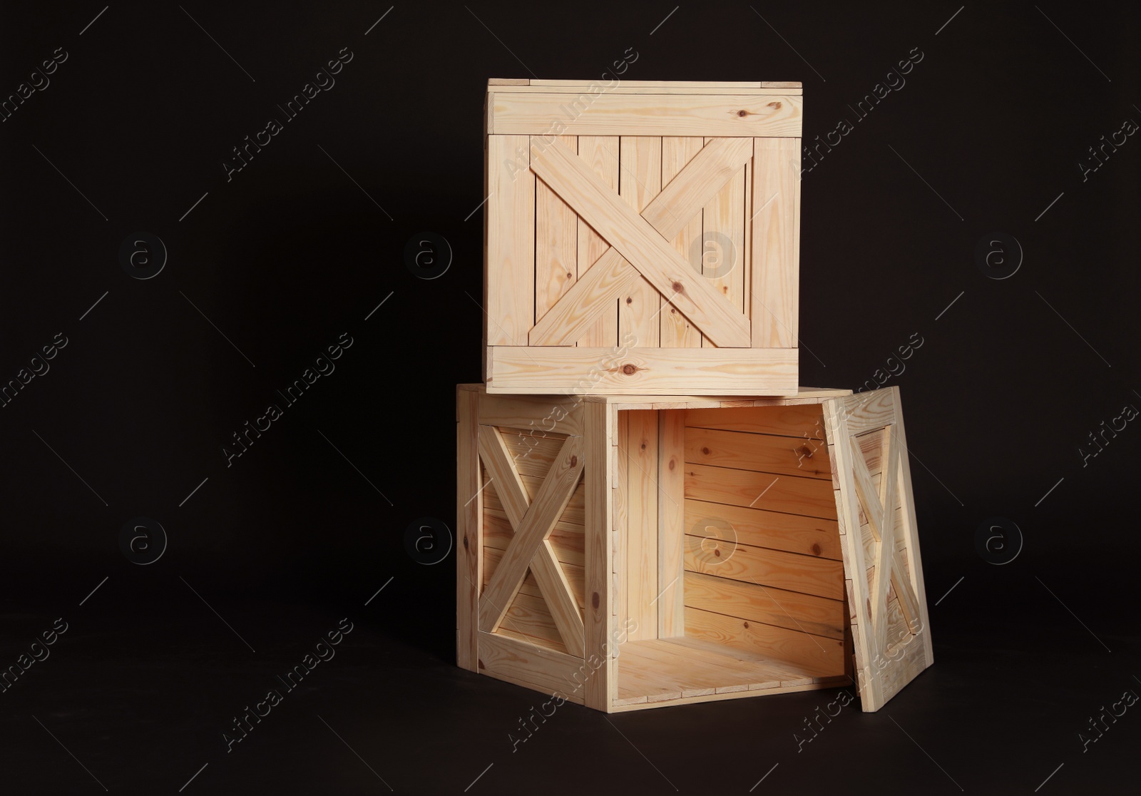 Photo of Wooden crates on black background. Space for text