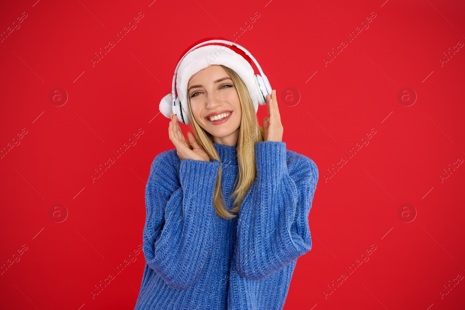 Photo of Happy woman with headphones on red background. Christmas music