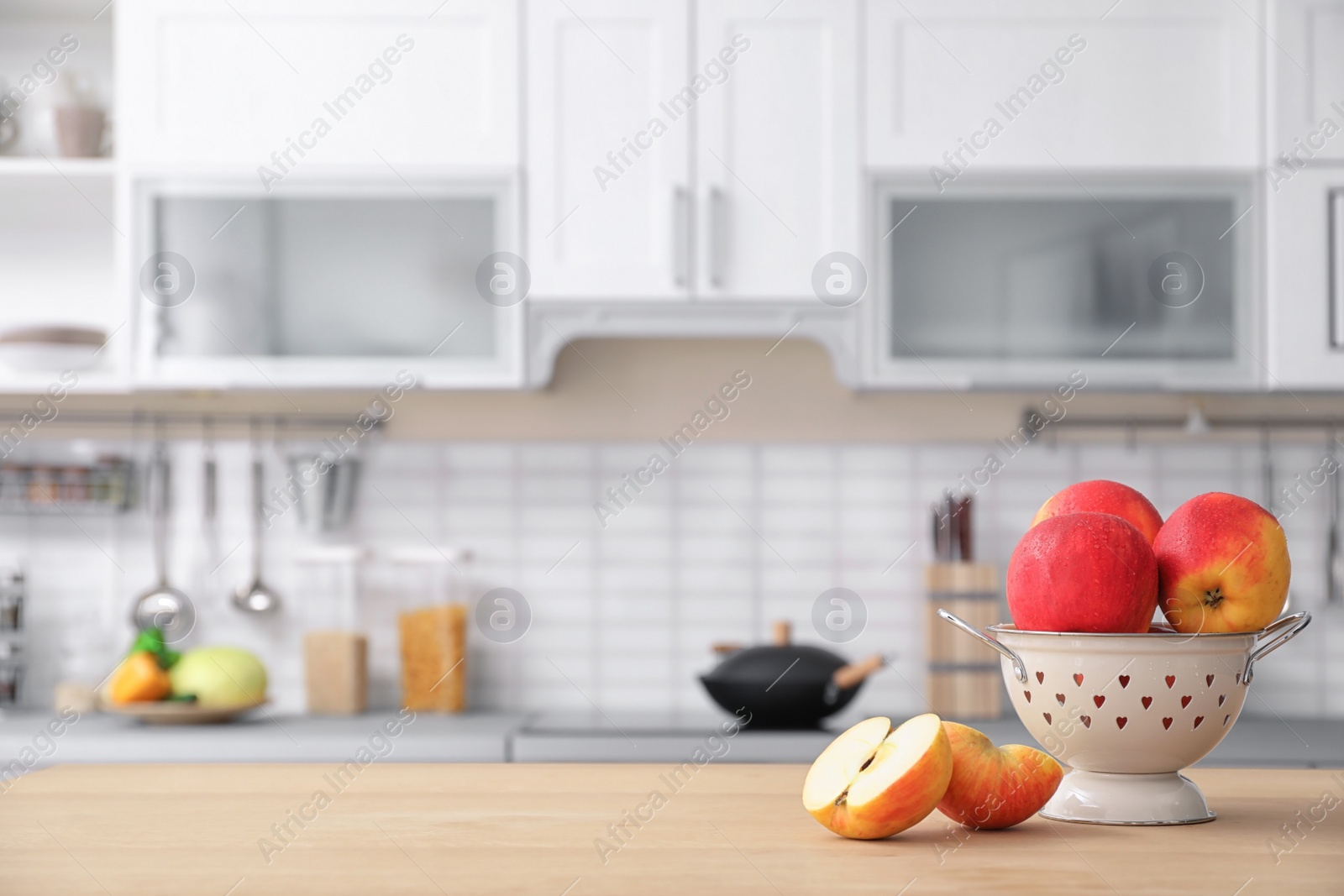 Photo of Ripe apples and blurred view of kitchen interior on background