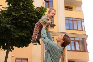 Nanny with cute little boy having fun outdoors