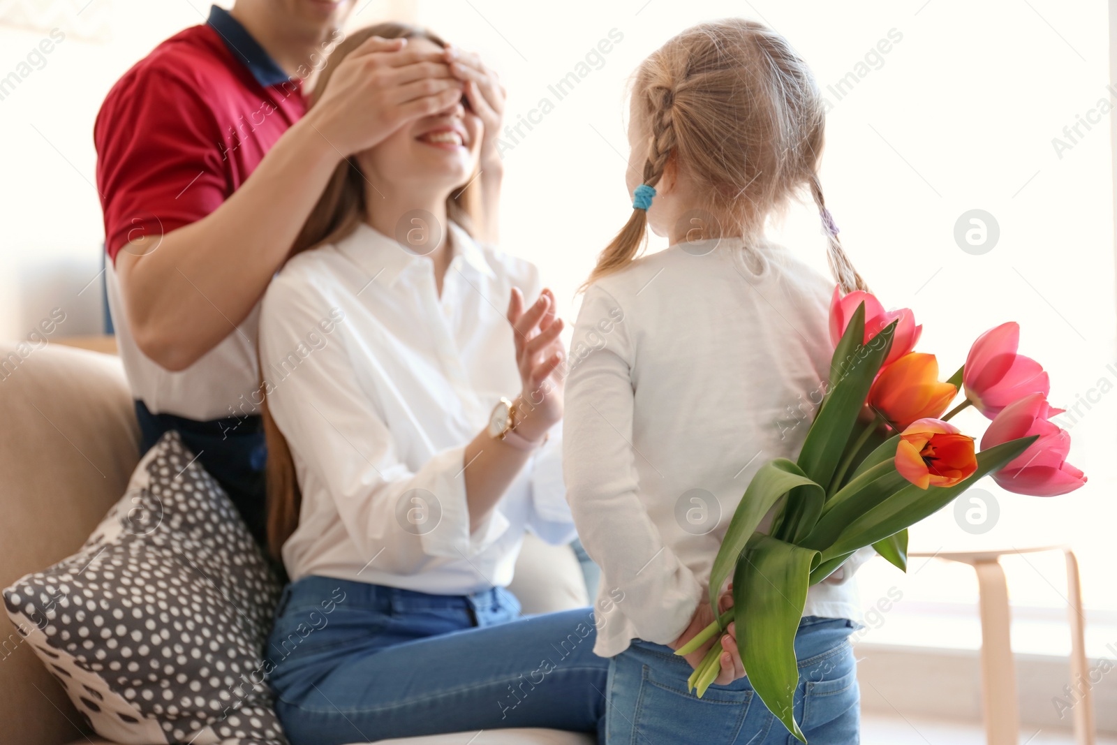 Photo of Happy family celebrating Mother's Day with bouquet of flowers