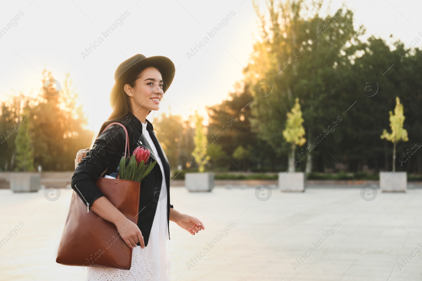 Photo of Young woman with leather shopper bag on city street