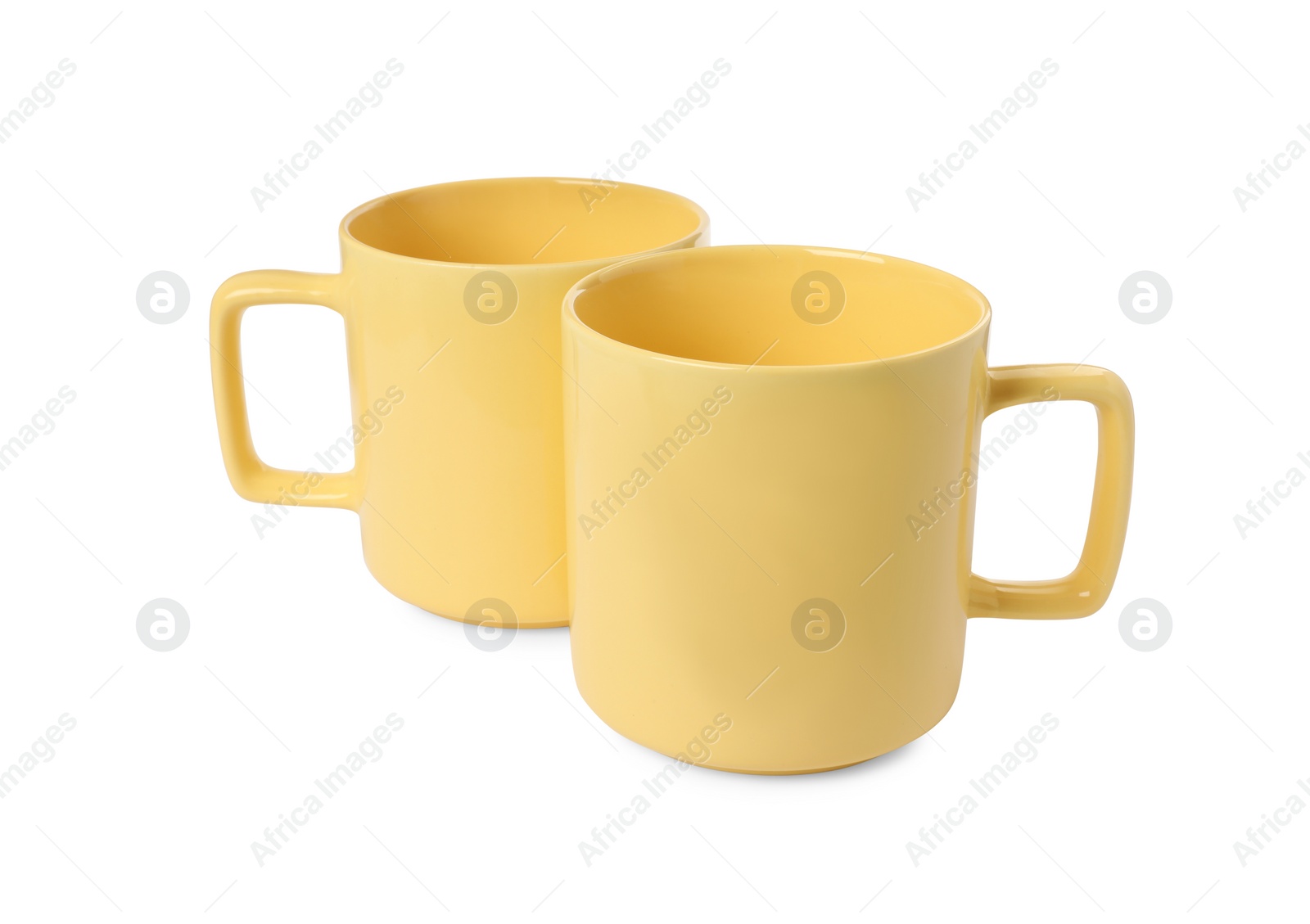 Photo of Two yellow ceramic mugs isolated on white