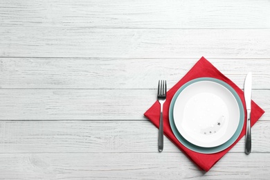 Photo of Patriotic table setting with traditional USA colors on wooden background, top view. Space for text