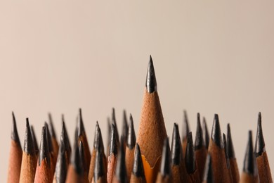 Many sharp graphite pencils on grey background, closeup. Space for text