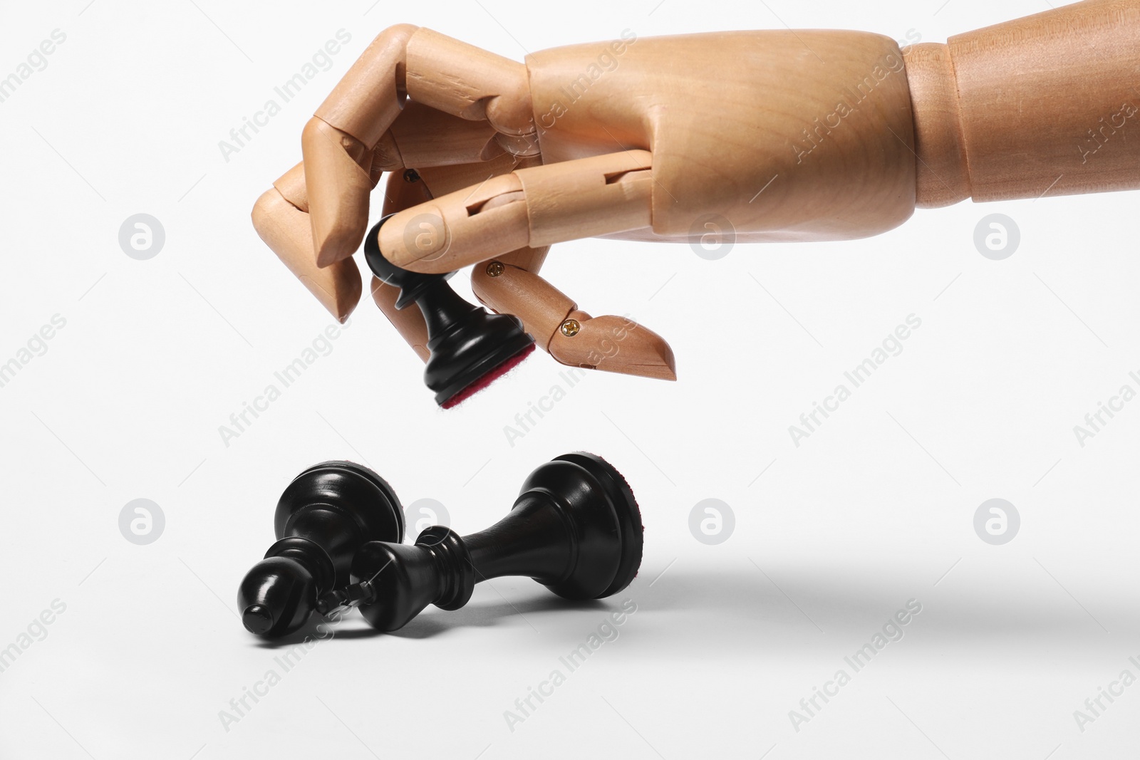 Photo of Robot holding pawn over other chess pieces on white background. Wooden hand representing artificial intelligence