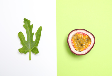 Photo of Half of fresh ripe passion fruit (maracuya) and green leaf on color background, flat lay