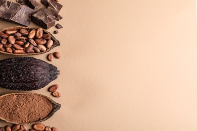 Photo of Flat lay composition with cocoa pods and chocolate on beige background, space for text