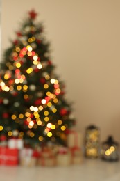 Beautiful tree decorated for Christmas and gift boxes indoors, blurred view. Interior design