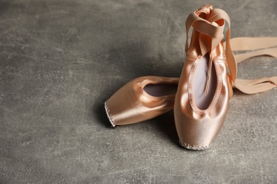 Photo of Ballet shoes. Elegant pointes on grey textured background, space for text