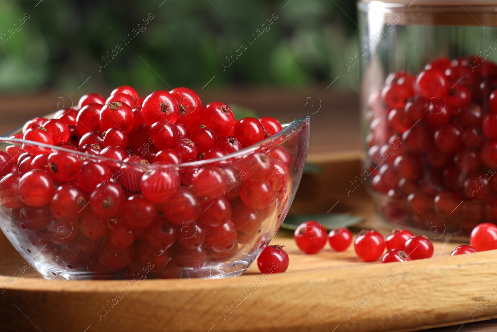 Photo of Ripe red currants and leaves on wooden table, closeup