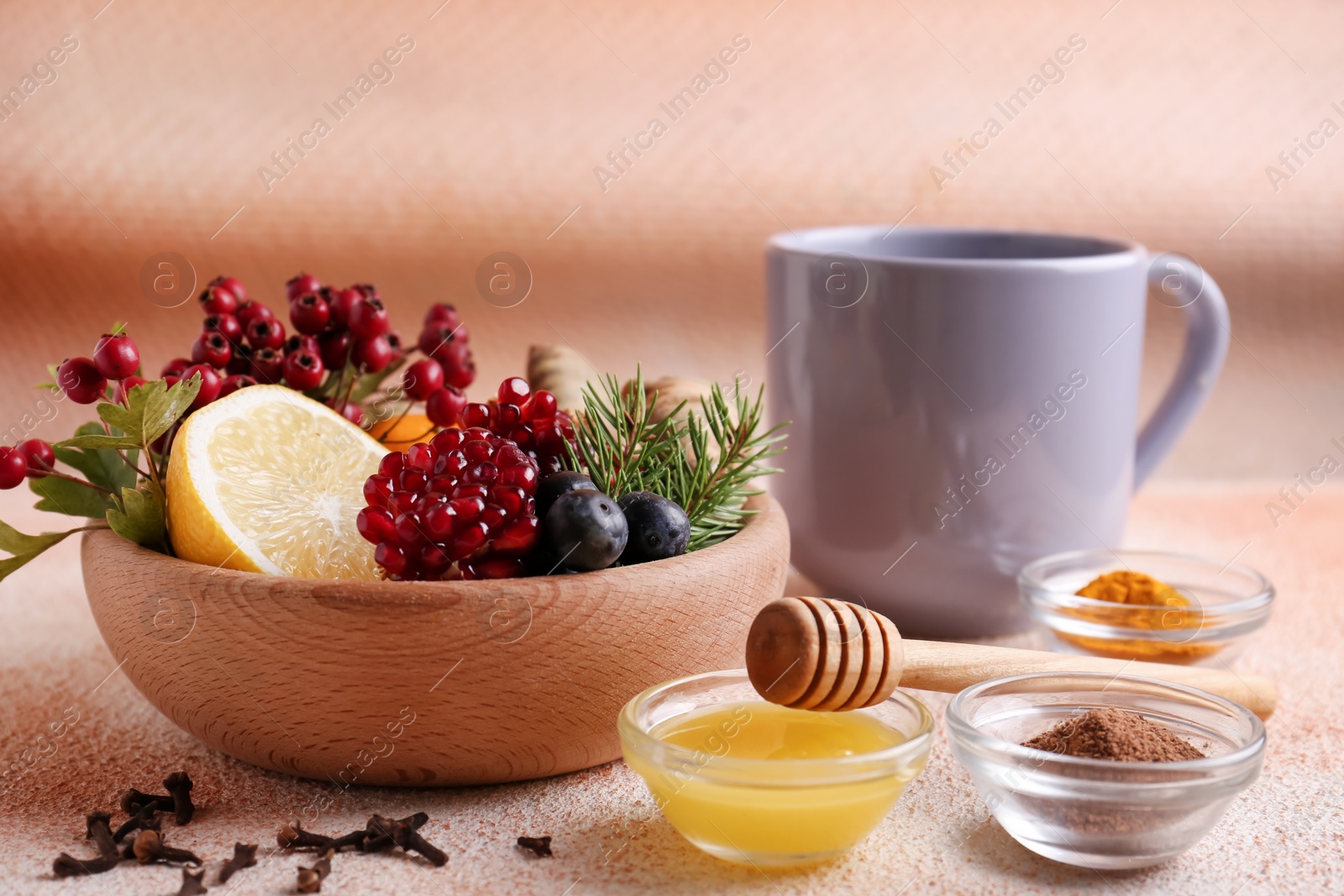 Photo of Cup of delicious immunity boosting tea and ingredients on color textured background