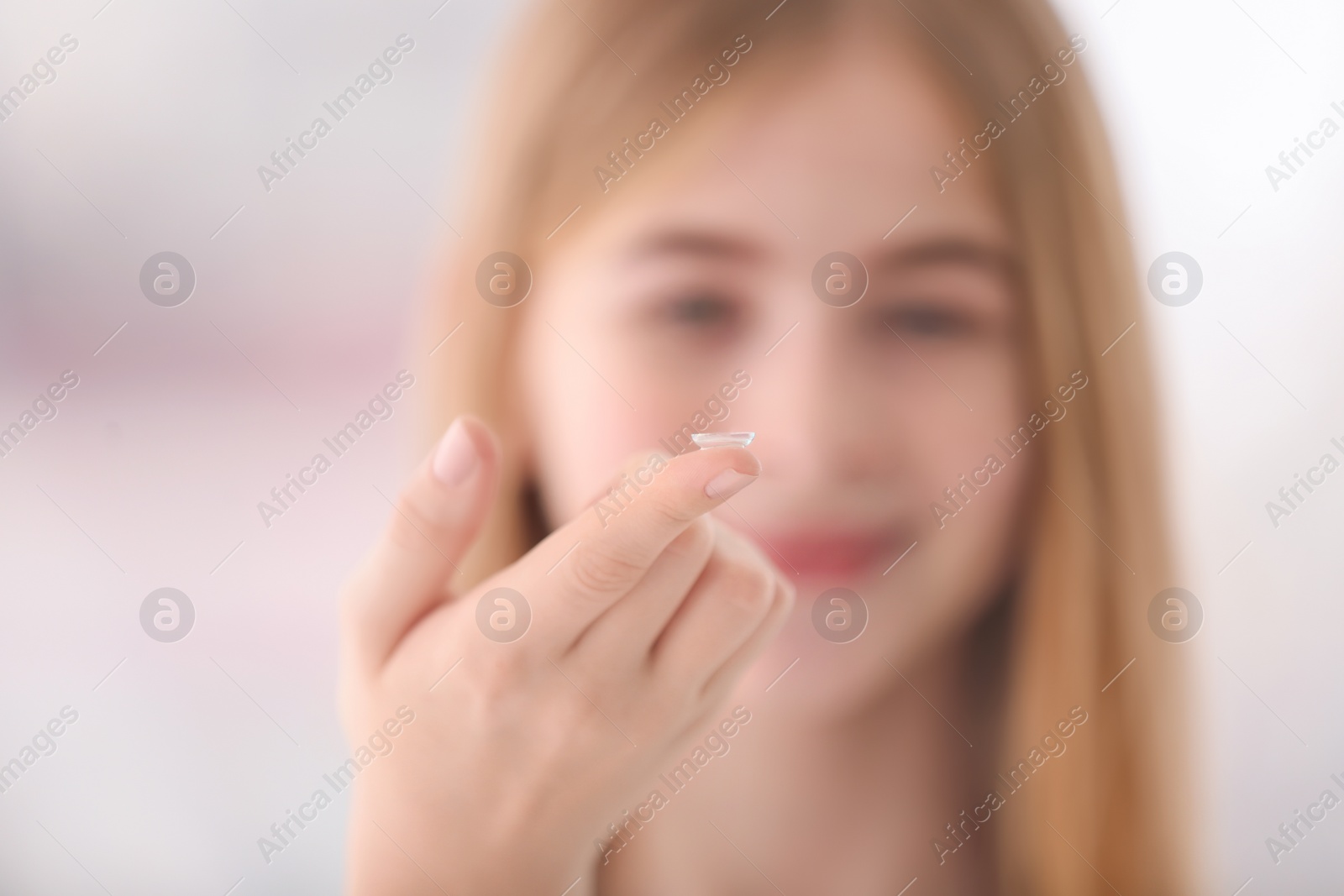 Photo of Teenage girl with contact lens on blurred background