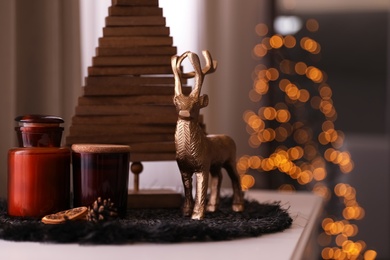 Photo of Composition with decorative Christmas tree and reindeer on light table, closeup