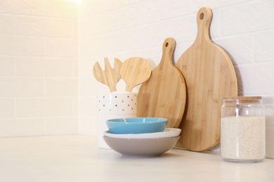 Photo of Wooden boards and different kitchen items on countertop indoors