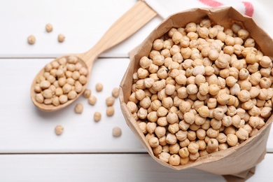 Photo of Chickpeas on white wooden table, flat lay. Space for text