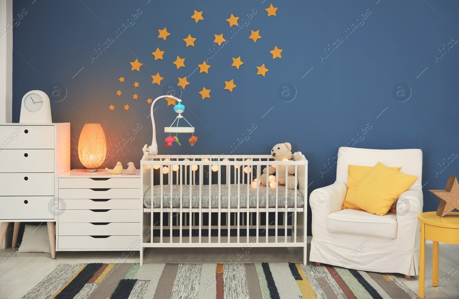 Photo of Baby room interior with comfortable crib and armchair