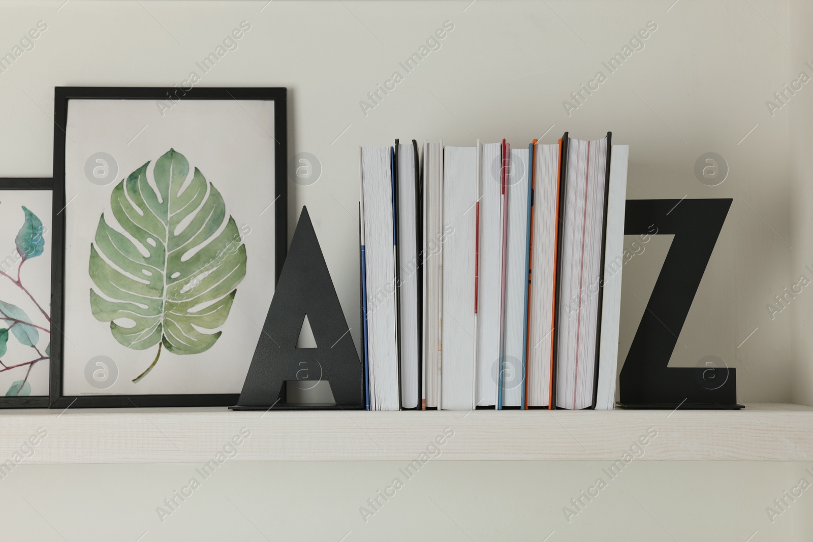 Photo of Bookends with books and pictures on shelf indoors