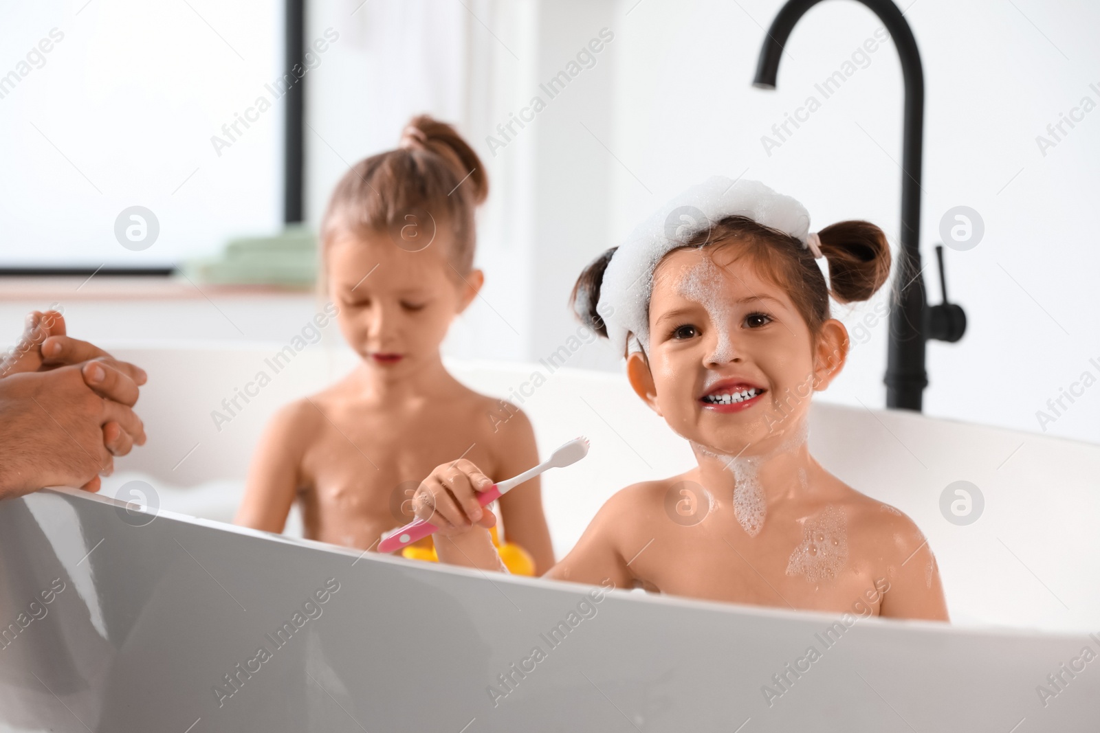 Photo of Young father with little daughters in bathroom