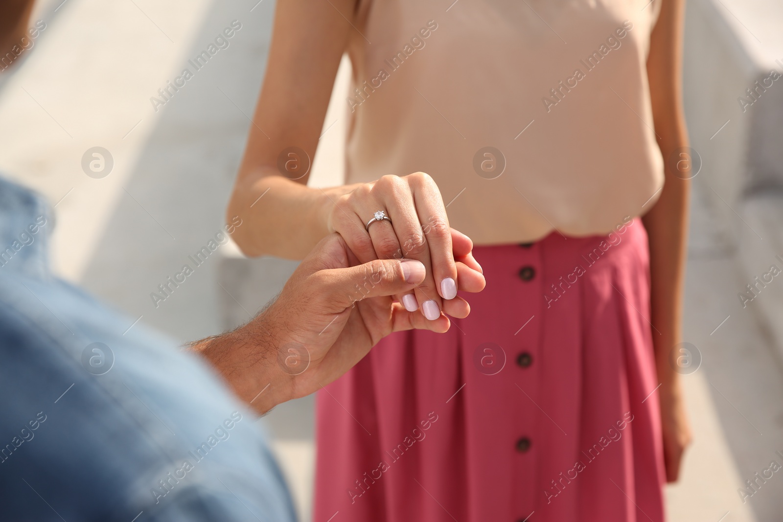 Photo of Lovely couple with beautiful ring after engagement outdoors, closeup