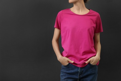 Photo of Woman in bright t-shirt on dark background. Mock up for design