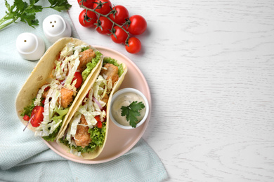 Photo of Yummy fish tacos served on white wooden table, flat lay. Space for text