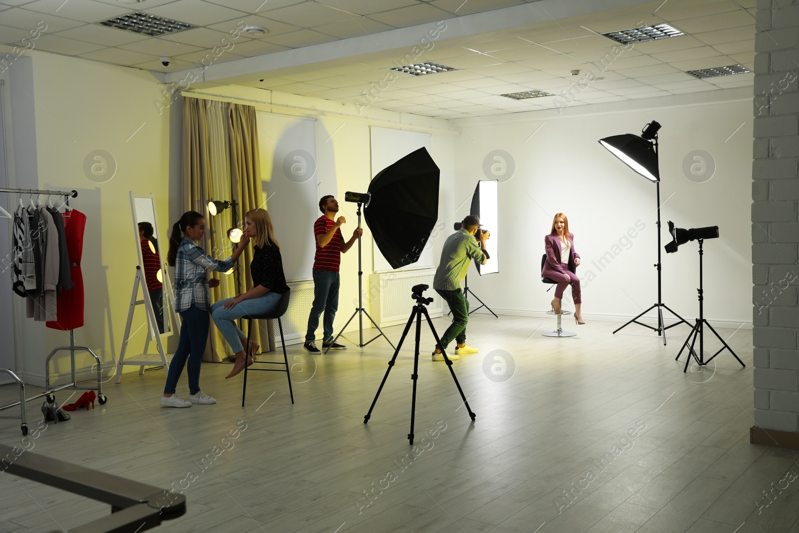 Photo of Photo studio with professional equipment and team of workers