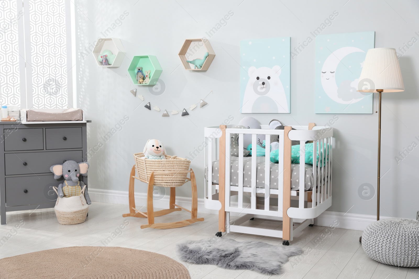 Photo of Cozy baby room with crib and other furniture. Interior design