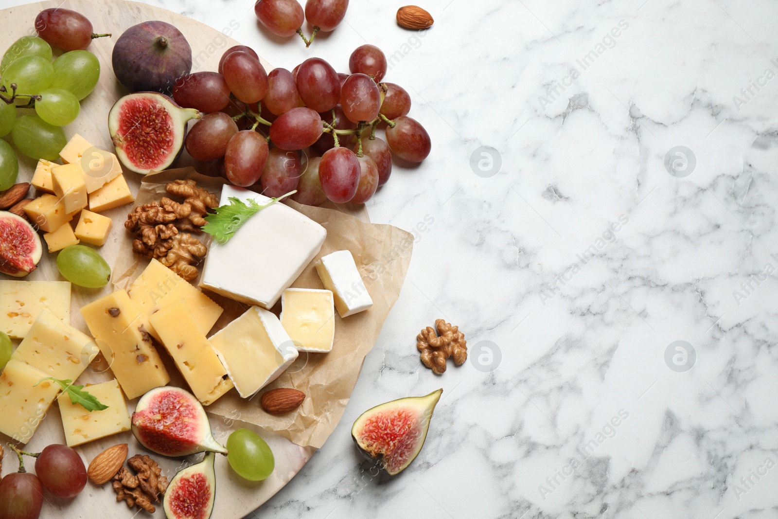 Photo of Set of different snacks with ripe figs served on marble table, flat lay. Space for text