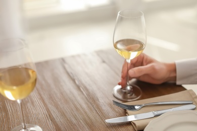 Man with glass of wine at table in restaurant