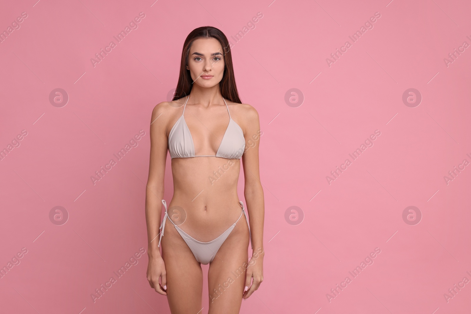 Photo of Young woman in stylish bikini on pink background