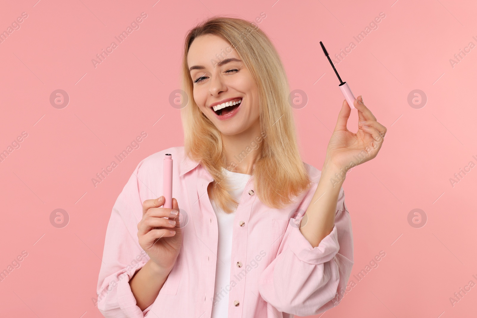 Photo of Beautiful woman with mascara on pink background