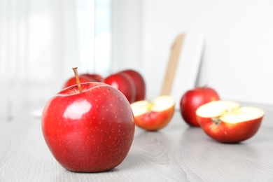 Photo of Ripe juicy red apples on white wooden table indoors