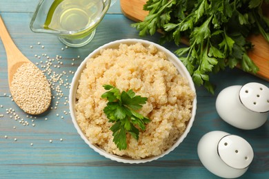 Photo of Flat lay composition with tasty quinoa porridge in bowl on light blue wooden table