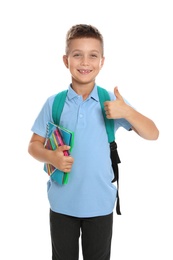 Photo of Cute little boy in school uniform with backpack and stationery showing thumbs-up on white background